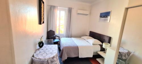 a small bedroom with a bed and a window at SeaYouSoon Inn Cannes - Studios in Cannes