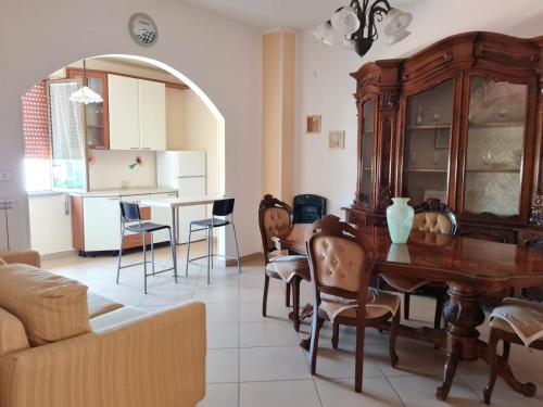 ein Wohnzimmer mit einem Holztisch und Stühlen in der Unterkunft Appartamenti & Camere TRA SCILLA e TROPEA in San Ferdinando
