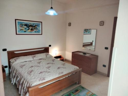 Schlafzimmer mit einem Bett, einer Kommode und einem Spiegel in der Unterkunft Appartamenti & Camere TRA SCILLA e TROPEA in San Ferdinando