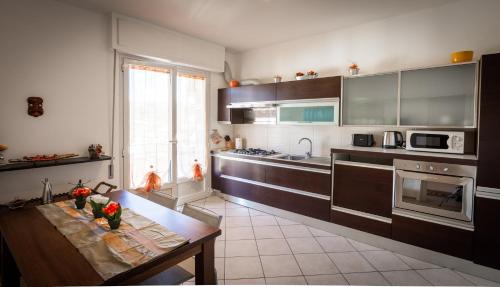 una cocina con armarios marrones y una mesa con flores. en RelaxHome, en Santo Stefano di Magra