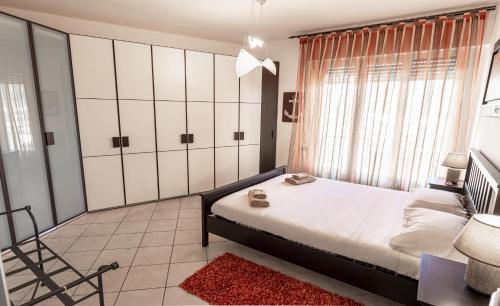 1 dormitorio con 1 cama, 1 silla y 1 ventana en RelaxHome, en Santo Stefano di Magra