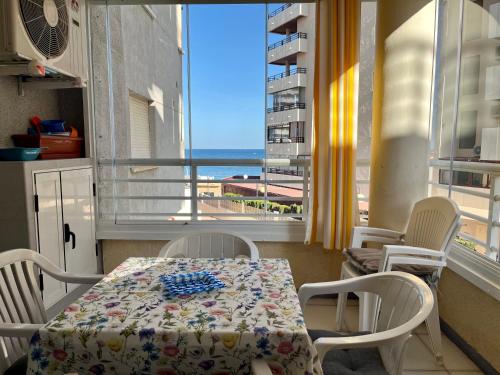 a table and chairs in a room with a view of the ocean at Apartment on the beach with parking and pool in Calpe