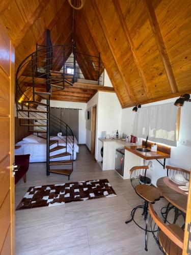 a room with a bed and a spiral staircase at VILLA ITÁLIA CHALÉ in Santo Antônio do Pinhal