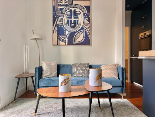 a living room with a blue couch and a table at Le Dijontissime Appartements haut de Gamme Dijon centre in Dijon