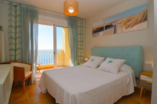 カンポアモールにあるPrecioso Duplex frente al mar en Campoamor Alicanteのベッドルーム1室(ベッド1台、大きな窓付)