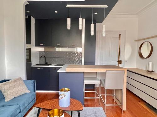 Il comprend une cuisine et un salon doté d'un canapé bleu. dans l'établissement Le Dijontissime Appartements haut de Gamme,CLimatisé, Dijon centre, à Dijon