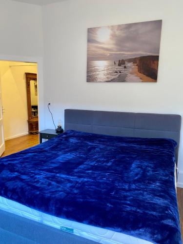 a bedroom with a bed with a blue comforter at Entspannt Mittendrin in Hannover