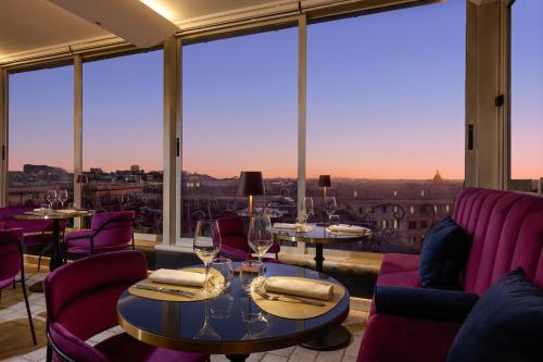 a restaurant with purple chairs and tables and large windows at Marcella Royal Hotel - Rooftop Garden in Rome