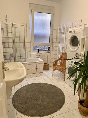 a bathroom with a tub sink and a washing machine at Entspannt Mittendrin in Hannover