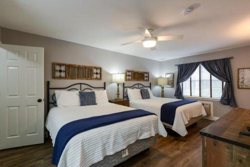 a bedroom with two beds with blue and white sheets at 2BR Penthouse Condo - Near The Strip - Free WIFI - Pool - FREE TICKETS INCLUDED - CLC-12 in Branson
