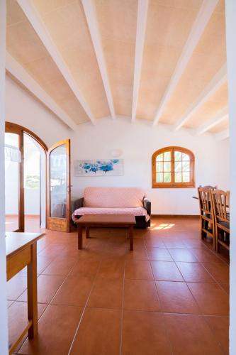 a living room with a couch and some chairs at Duplex Es Brucs in Cala Morell