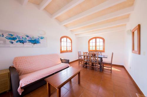 ein Wohnzimmer mit einem Sofa und einem Tisch in der Unterkunft Duplex Es Brucs in Cala Morell