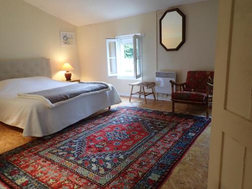 a bedroom with a bed and a rug on the floor at Maison Saloine in Saintes