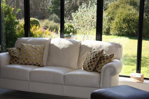 a white couch in front of a large window at White Lodge B&B in Cooksbridge