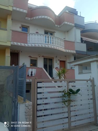 una casa con una cerca blanca delante de ella en Carone home, en Mola di Bari