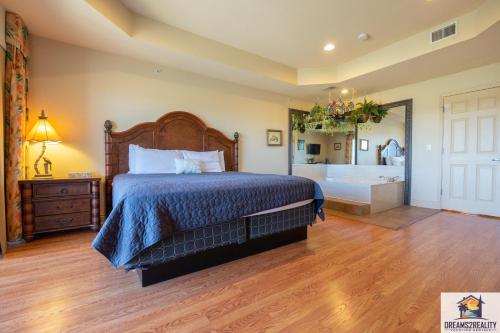 a bedroom with a large bed and a bath tub at 1BD King Condo with 2 Person Jacuzzi Tub - Near The Strip - FREE TICKETS INCLUDED - T1-9 in Branson