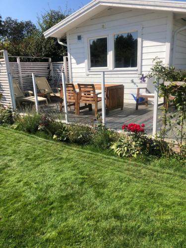 a patio with a table and chairs in front of a house at Gästhus vid hav och strand in Åsa