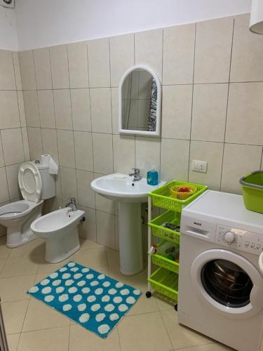 ein Badezimmer mit einem Waschbecken und einer Waschmaschine in der Unterkunft Casa vista mare a Shengjin in Shëngjin