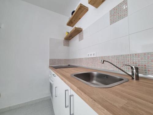 a kitchen with a sink and a wooden counter top at Piscina y Relax junto al Mar! in Corralejo