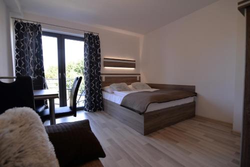 a bedroom with a bed and a desk and a window at Villa Bueno Bis in Rowy