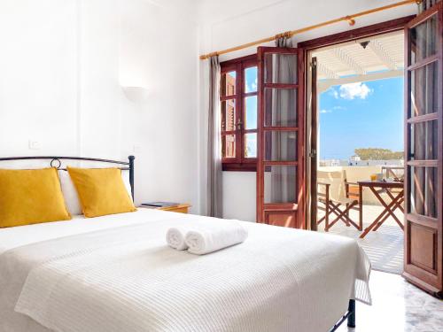 a bedroom with a bed with two towels on it at Almyra Villa in Perissa