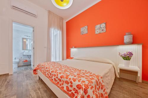 a bedroom with an orange wall and a bed at ILICE B&B in Lecce