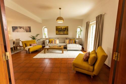 - un salon avec des fauteuils jaunes et un canapé dans l'établissement Spacious 3 bedroom house w/ swimming pool, à Ericeira