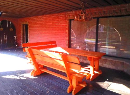 una mesa de madera y un banco en un porche en Great place, en Riga