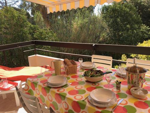 d'une table avec un chiffon de polka sur une terrasse dans l'établissement Appartement 2 pièces climatisé avec accès direct plage, parking et terrasse - Le Lavandou - FR-1-308-175, au Lavandou