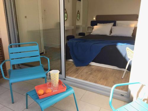 1 dormitorio con 1 cama, 1 silla azul y 1 mesa en Appartement Le Lavandou, 2 pièces, 4 personnes - FR-1-308-175, en Le Lavandou