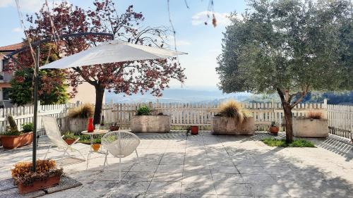 patio con ombrellone, tavolo e sedie di Panoramico10 Apartment with a view in Valpolicella a SantʼAmbrogio di Valpolicella