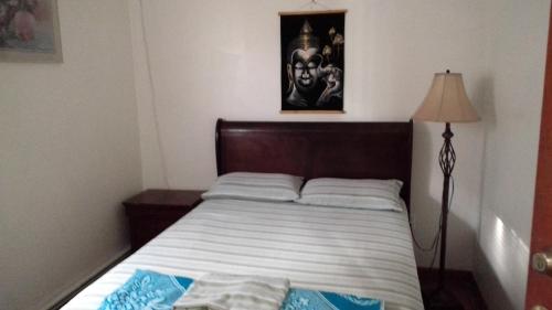sypialnia z łóżkiem z drewnianym zagłówkiem i lampką w obiekcie HOVA HOUSE NORTH w mieście Elizabeth