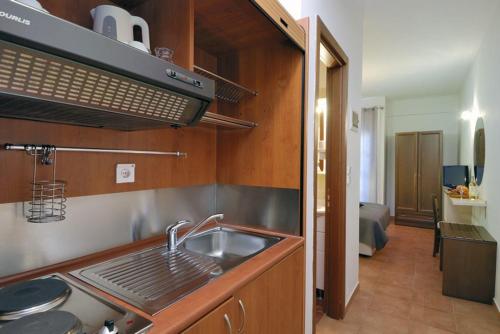 a kitchen with a sink and a stove top oven at Enalion Hotel in Kala Nera