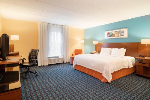 a hotel room with a bed and a desk and a television at Fairfield Inn by Marriott Laurel in Laurel