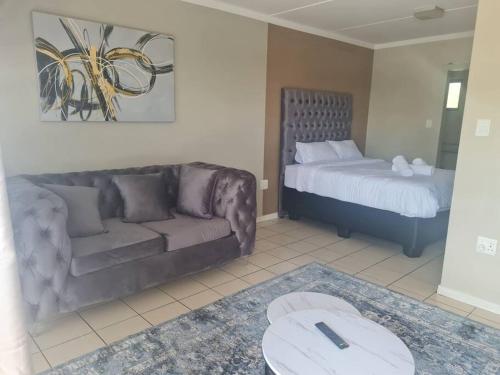 a living room with a couch and a bed at Tripleg Apartments 1 in Fourways