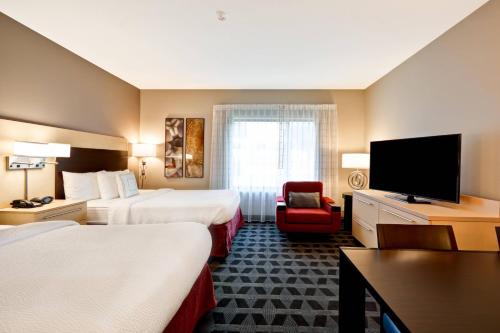 Habitación de hotel con 2 camas y TV de pantalla plana. en TownePlace Suites Dallas/Lewisville, en Lewisville
