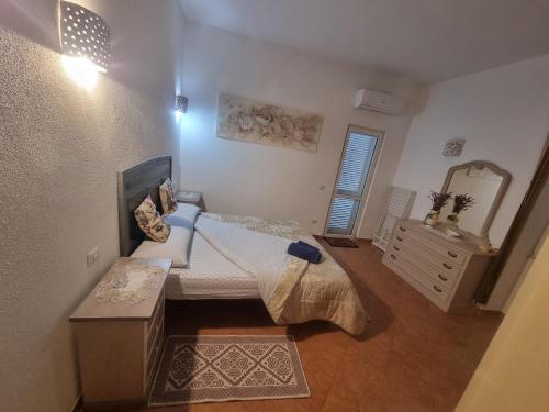 a bedroom with a bed and a dresser and a mirror at Appartamento Monte Mare Arzachena in Arzachena