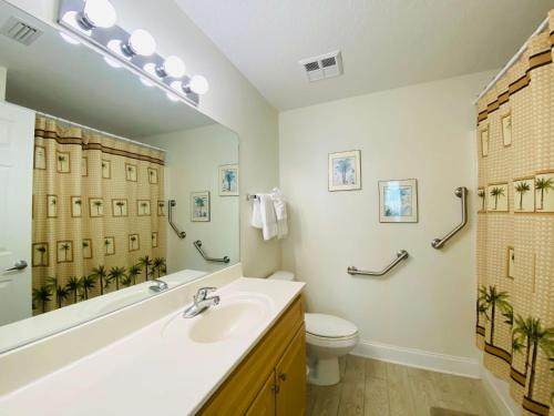 y baño con lavabo, aseo y espejo. en Crystal Shores 1301 by ALBVR - Beautiful Beachfront Corner Condo with Gorgeous Views! en Gulf Shores