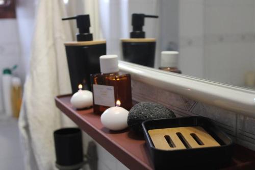 a bathroom with a shelf with candles and a mirror at Rodi Apartment 2 in Kamari