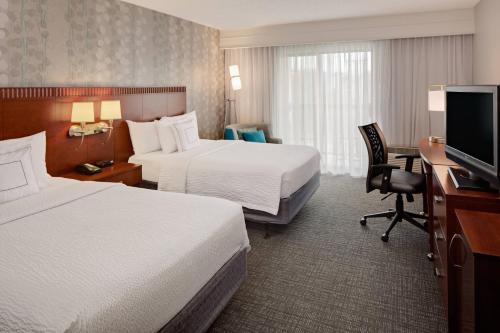 沃思堡的住宿－西沃斯堡I-30萬怡酒店（靠近NAS JRB），酒店客房设有两张床、一张桌子和一台电视。