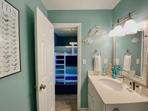a bathroom with a sink and a bunk bed at Grand Beach 315 by ALBVR - Come relax at our beautiful condo in the heart of Gulf Shores! in Gulf Shores