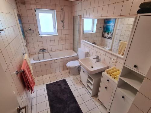 a bathroom with a sink and a tub and a toilet at Ferienwohnung Steigerwald Gerolzhofen in Gerolzhofen
