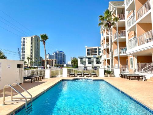 a swimming pool in the middle of a apartment building at Grand Beach 315 by ALBVR - Come relax at our beautiful condo in the heart of Gulf Shores! in Gulf Shores