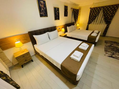 a hotel room with two beds and a table at Sirius Pamukkale in Pamukkale