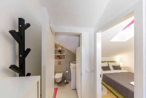 a small white room with a bed and a bathroom at Apartman Merita in Dubrovnik