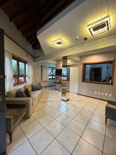 a large living room with a couch and a tv at Pousada Villa Verde in Canela