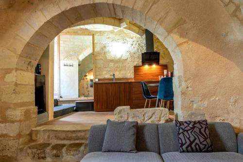 a living room with a couch and an archway at Les pieds dans le Château - Jacuzzi in Amboise