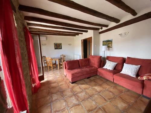 sala de estar con sofá rojo y mesa en Casa Nemesio, enclave y vistas excepcionales, en Valderrobres