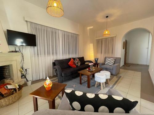 a living room with a couch and a fireplace at Nysa8 in Paphos City