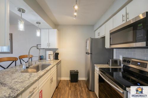 a kitchen with a sink and a stainless steel refrigerator at 1BR Walk-In Condo at Pointe Royal - 2 Pools - FREE TICKETS INCLUDED - PR40-9 in Branson